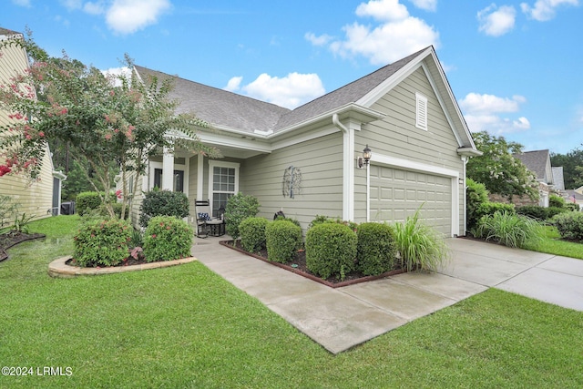 view of front facade featuring a garage, a front lawn, and a porch