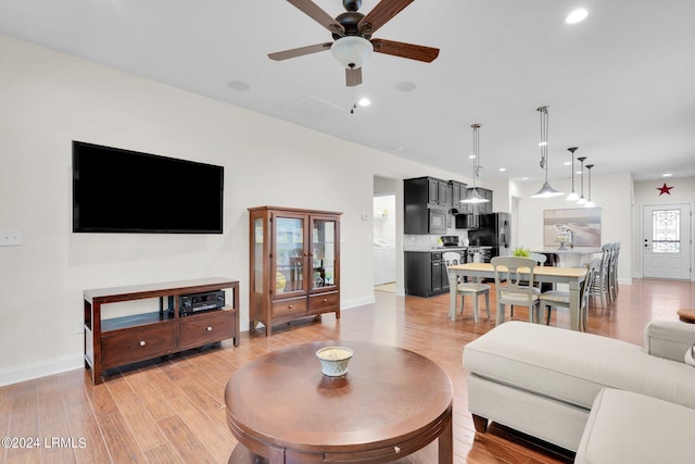 living room featuring ceiling fan and light hardwood / wood-style floors