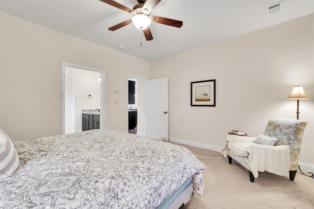 carpeted bedroom with ensuite bath and ceiling fan