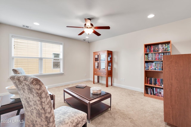 carpeted living room with ceiling fan