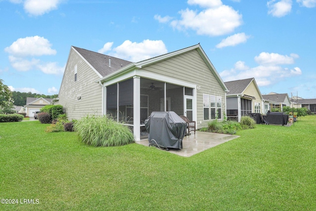 back of property with a patio, a sunroom, and a lawn