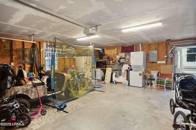 garage with a garage door opener, electric panel, and a workshop area