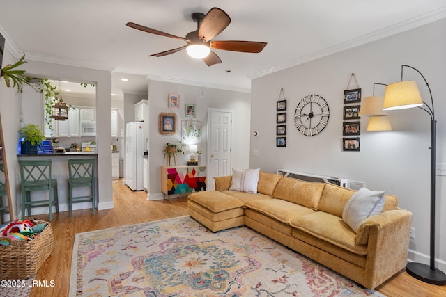 living room with crown molding, ceiling fan, and light wood-type flooring