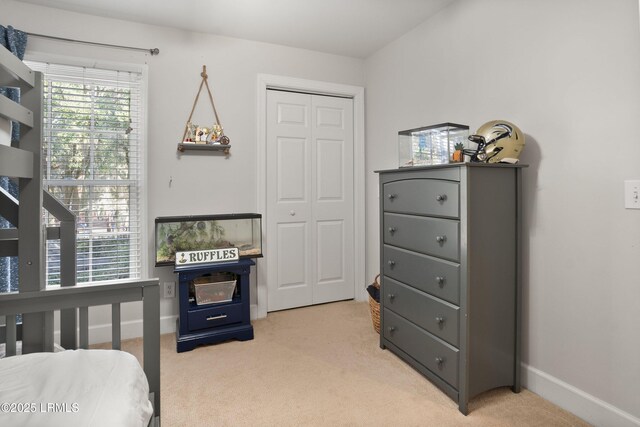 bedroom featuring light carpet and a closet