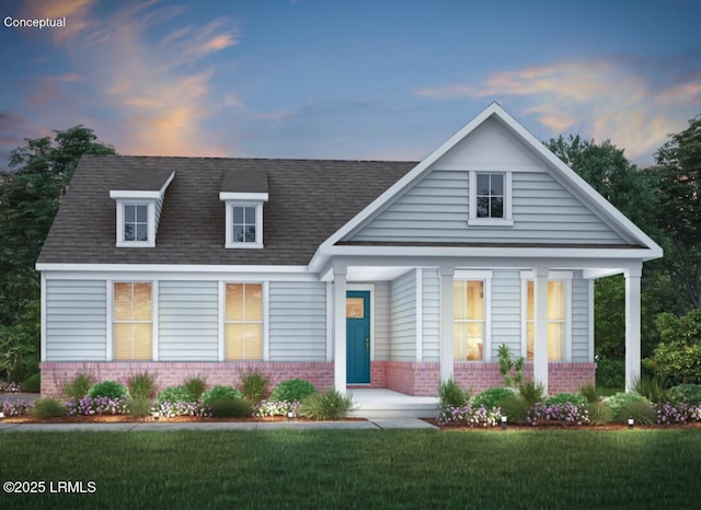 view of front of house with covered porch, a shingled roof, a lawn, and brick siding