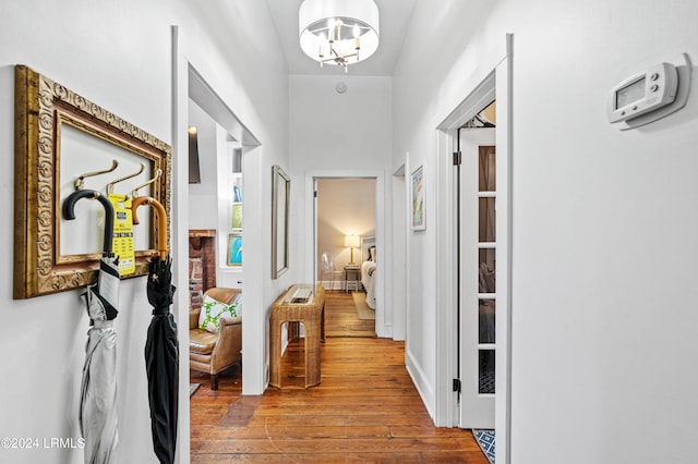 hallway featuring hardwood / wood-style flooring and a chandelier