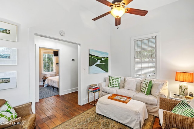 living room with dark wood-type flooring and ceiling fan