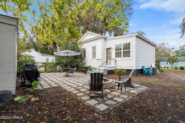 back of property with a patio area, a fire pit, and central air condition unit