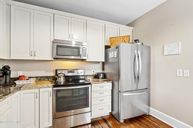 kitchen featuring dark wood-type flooring, stainless steel appliances, white cabinets, and stone countertops