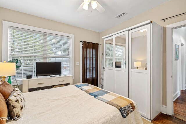 bedroom with dark hardwood / wood-style floors, a closet, and ceiling fan