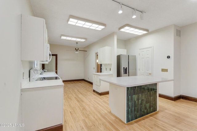 1 Royal James Dr, Hilton Head Island, SC 29926 - kitchen with stainless steel fridge, white cabinets, light countertops, and light wood finished floors