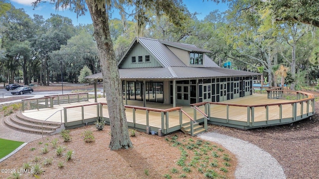 rear view of property featuring a sunroom and a deck