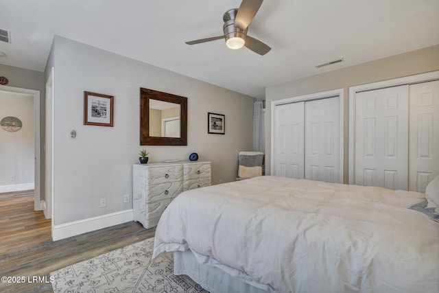 bedroom with multiple closets, ceiling fan, and hardwood / wood-style flooring