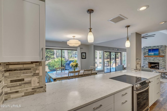 kitchen featuring light stone counters, hanging light fixtures, stainless steel range with electric cooktop, and white cabinets