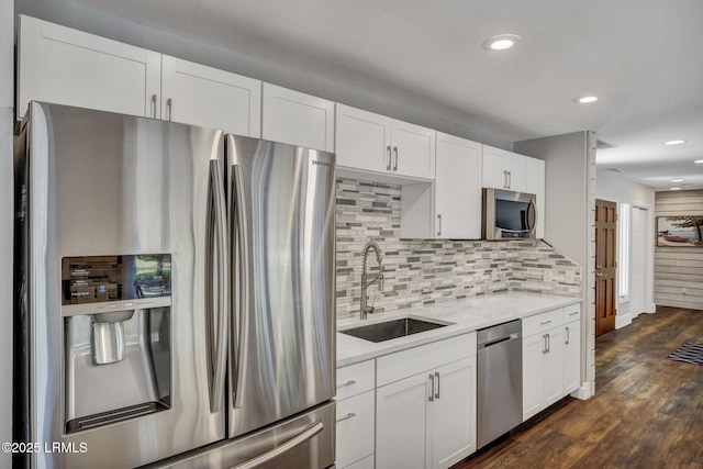 kitchen with white cabinetry, appliances with stainless steel finishes, sink, and dark hardwood / wood-style flooring