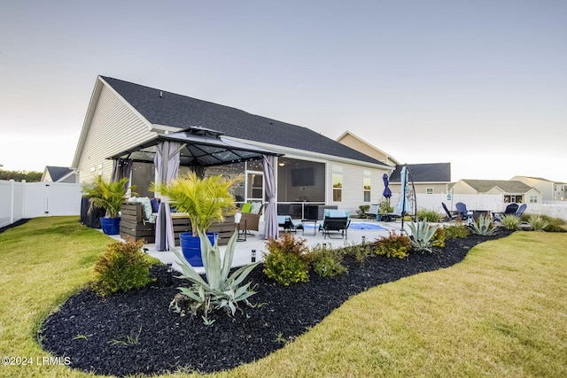 rear view of house featuring a gazebo, outdoor lounge area, a yard, and a patio area