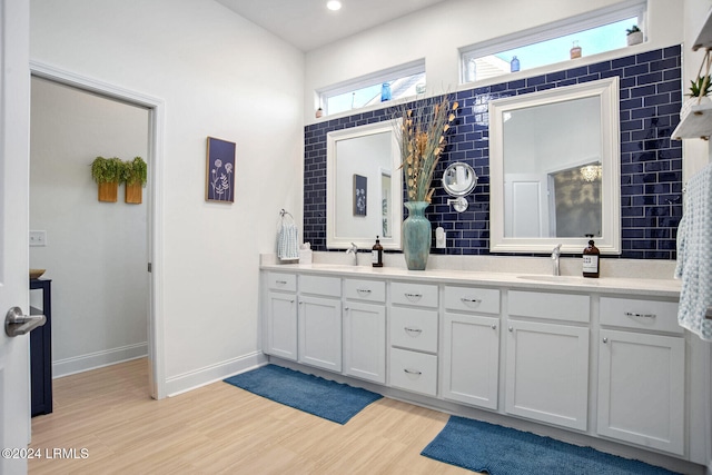 bathroom featuring hardwood / wood-style flooring, vanity, and backsplash