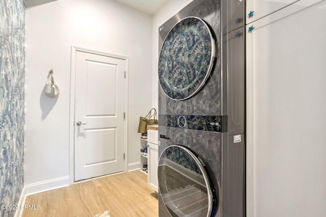 laundry room featuring stacked washer / drying machine and light hardwood / wood-style flooring