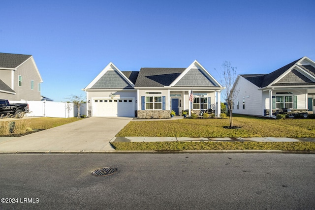 craftsman inspired home with a garage and a front lawn