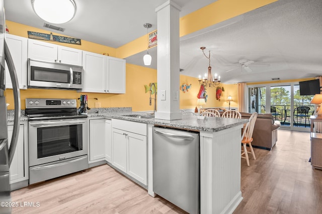167 Beach Club Villa Dr Unit 167, Fripp Island, SC 29920 - kitchen with stainless steel appliances, lofted ceiling, open floor plan, light wood-type flooring, and a peninsula
