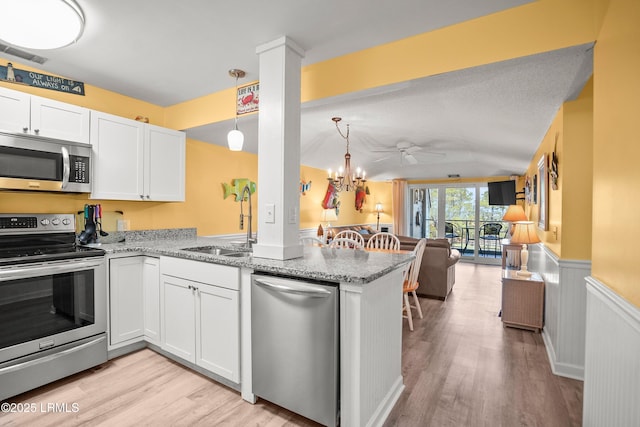 167 Beach Club Villa Dr Unit 167, Fripp Island, SC 29920 - kitchen featuring stainless steel appliances, open floor plan, light wood-style floors, a peninsula, and white cabinetry