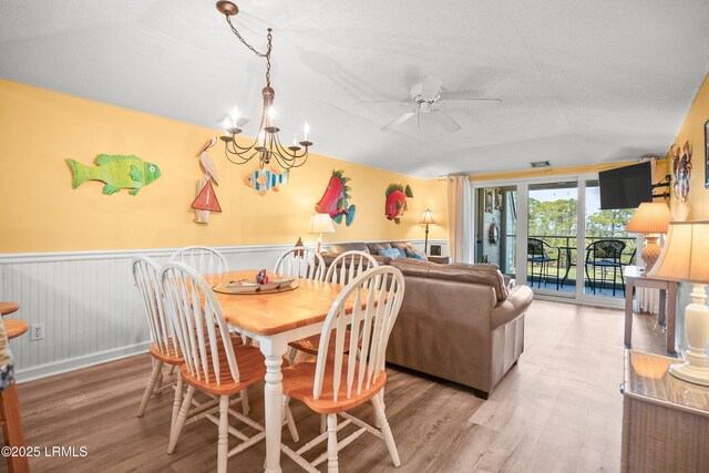 167 Beach Club Villa Dr Unit 167, Fripp Island, SC 29920 - dining area with light wood-style floors, vaulted ceiling, ceiling fan, a wainscoted wall, and a chandelier