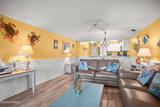 167 Beach Club Villa Dr Unit 167, Fripp Island, SC 29920 - living room with a ceiling fan, wood finished floors, a wainscoted wall, and a chandelier