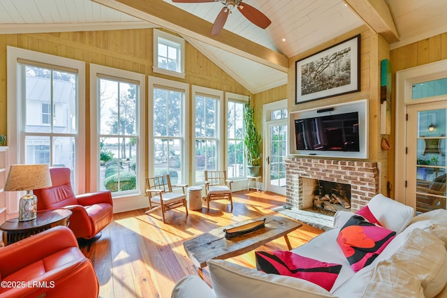 living area featuring wood-type flooring, a brick fireplace, wood walls, and vaulted ceiling with beams