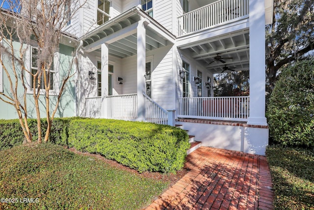 property entrance with a balcony, a porch, and a ceiling fan