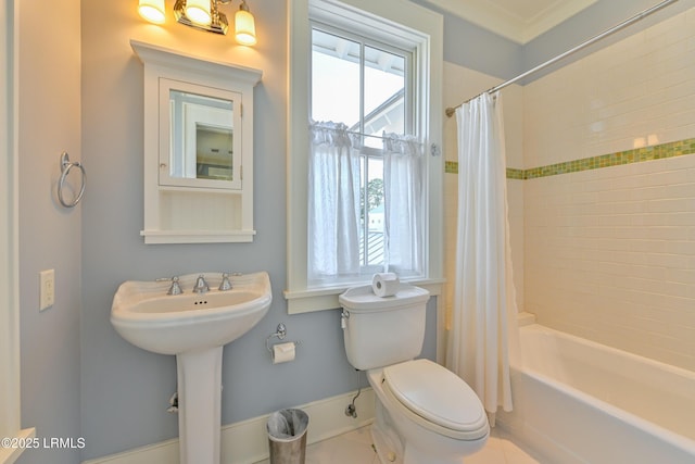 full bathroom featuring tile patterned flooring, baseboards, toilet, shower / tub combo, and a sink