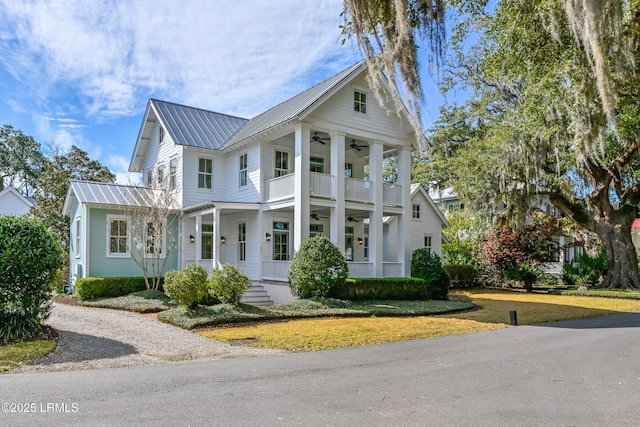 view of front of house featuring a front lawn, a porch, metal roof, a balcony, and a ceiling fan