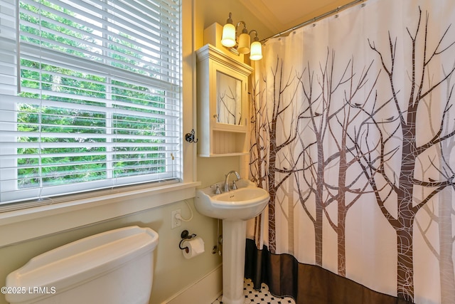 full bathroom with curtained shower, toilet, and a sink