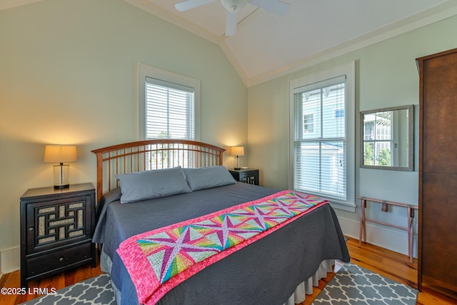 bedroom featuring lofted ceiling, crown molding, wood finished floors, and ceiling fan