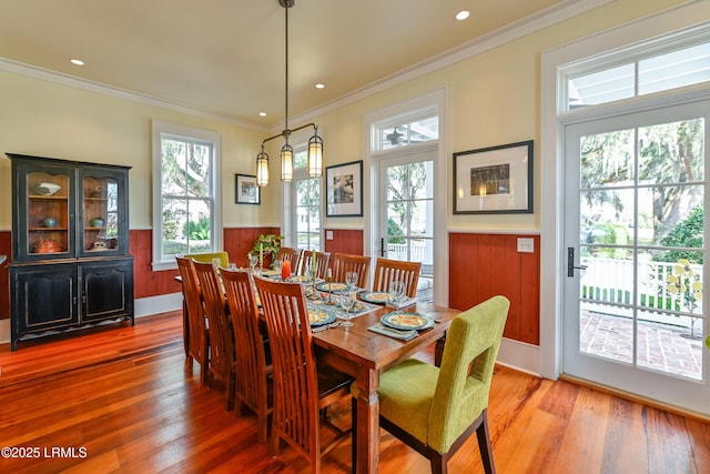 dining space featuring crown molding, recessed lighting, light wood-style floors, and wainscoting