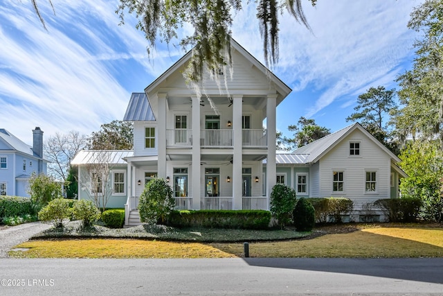 greek revival house with ceiling fan, covered porch, metal roof, a balcony, and a standing seam roof