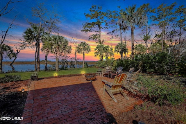 view of patio with a water view and a fire pit