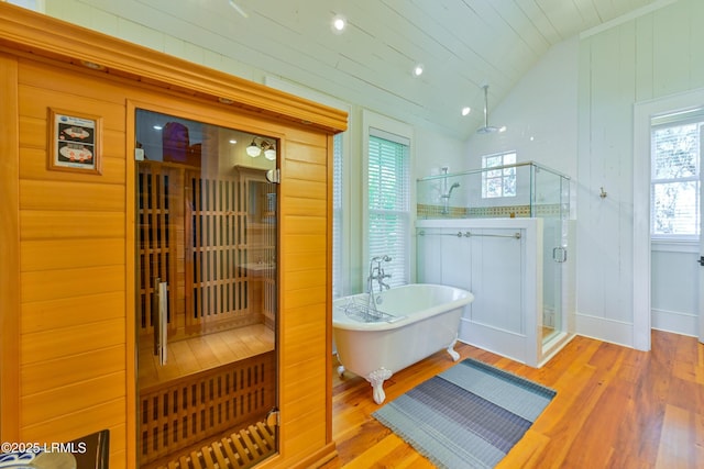 full bathroom with lofted ceiling, a soaking tub, wood finished floors, and a stall shower