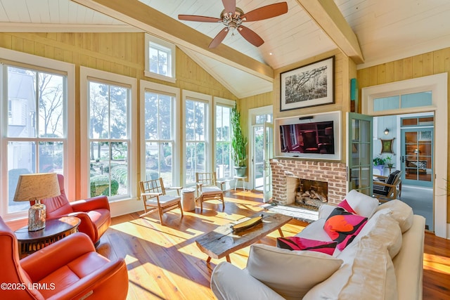 sunroom / solarium featuring a brick fireplace, wooden ceiling, vaulted ceiling with beams, and a healthy amount of sunlight