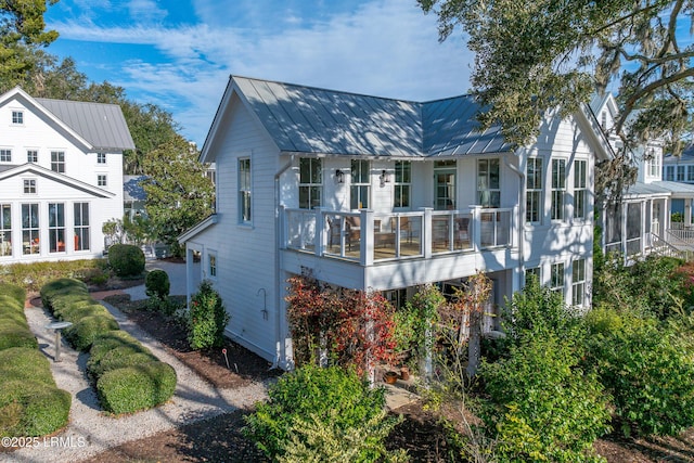 exterior space featuring metal roof, a standing seam roof, and a sunroom