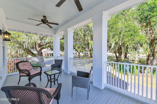 wooden deck featuring covered porch and a ceiling fan