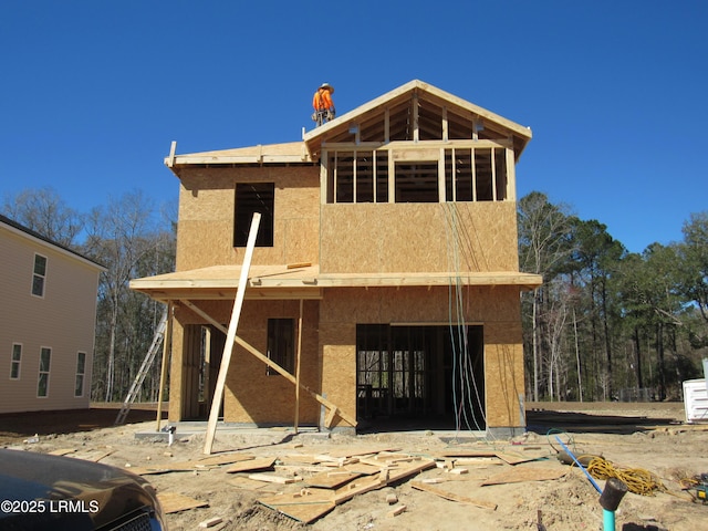 rear view of house featuring a garage and stucco siding