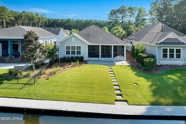 back of house featuring a yard and a sunroom