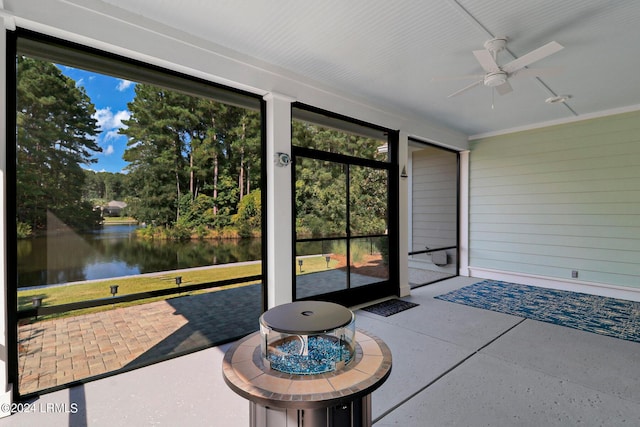 unfurnished sunroom with a water view and ceiling fan