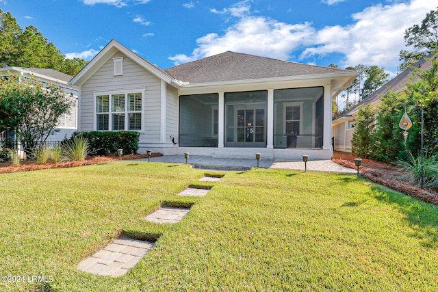 rear view of house with a lawn and a sunroom