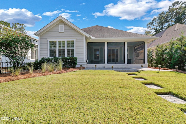 rear view of property featuring a sunroom and a yard