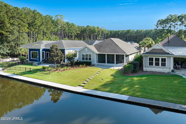 view of front of property featuring a water view, a front yard, a sunroom, and a patio area