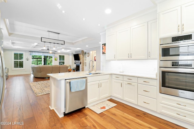 kitchen featuring white cabinetry, stainless steel appliances, kitchen peninsula, and sink