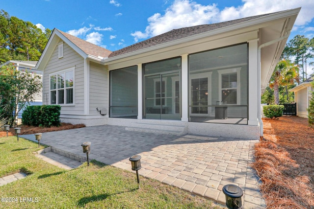 rear view of property featuring a sunroom and a patio