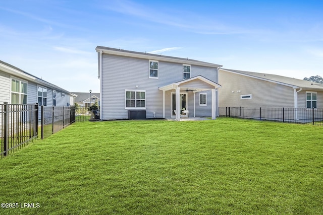 back of property with ceiling fan, a patio, a lawn, and a fenced backyard