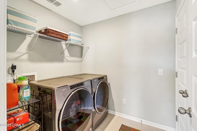 laundry room with light tile patterned floors, laundry area, visible vents, baseboards, and washer and dryer